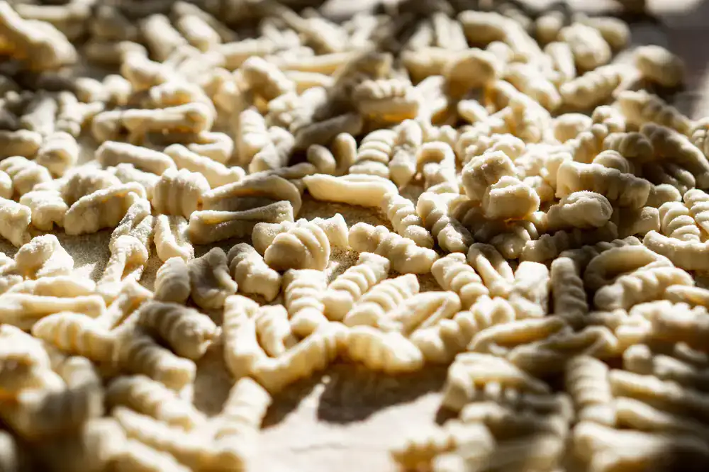 Freshly made artisan pasta displayed neatly on a marble store counter